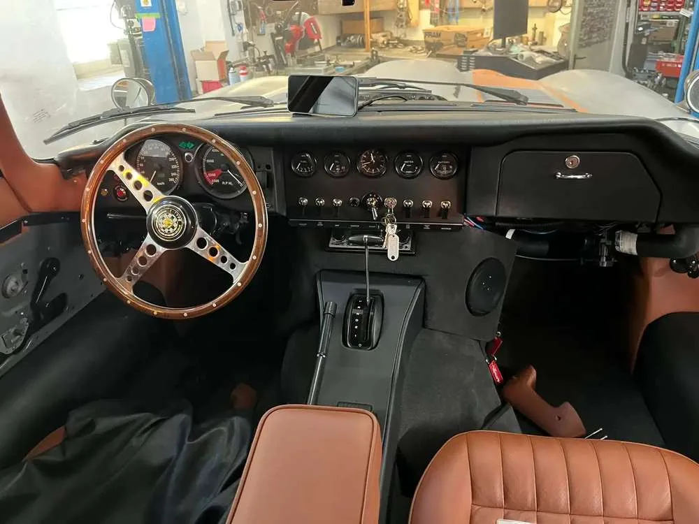 Cabin with wood-rimmed wheel, period-style gauges and saddle leather