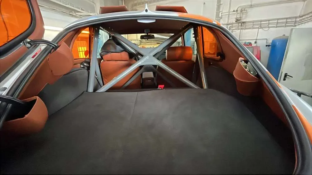 Motorsport roll cage and trimmed load bay seen through the rear hatch